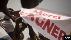 FILE: Protesters holds a banner reading "Thank you Wagner" during a demonstration to celebrate France's announcement to withdraw its troops from Mali, in Bamako, on February 19, 2022. The Wagner Group has been accused of war crimes in several African nations, including Mali.