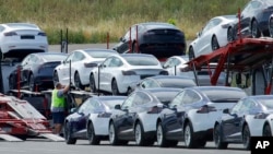 FILE - Tesla cars are loaded onto carriers at the Tesla electric car plant in Fremont, Calif., May 13, 2020.