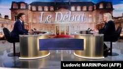 Le président français et candidat à sa propre réélection Emmanuel Macron (à g.) et la candidate de l'opposition Marine Le Pen participent à un débat télévisé en direct, mercredi 20 avril 2022.