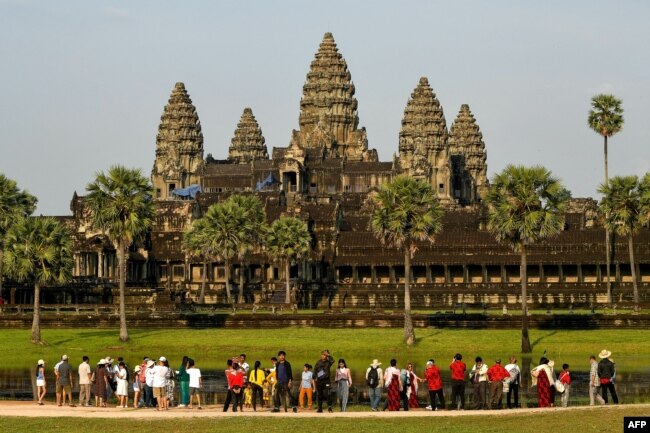This picture taken on April 7, 2022 shows tourists visiting the Angkor Wat temple complex, a UNESCO World Heritage Site, in Siem Reap province. (Photo by TANG CHHIN Sothy / AFP)