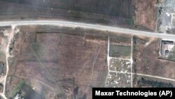 Satelitski snimci pokazuju četiri reda grobova koji se naslanjaju na groblje kod Mariupolja.