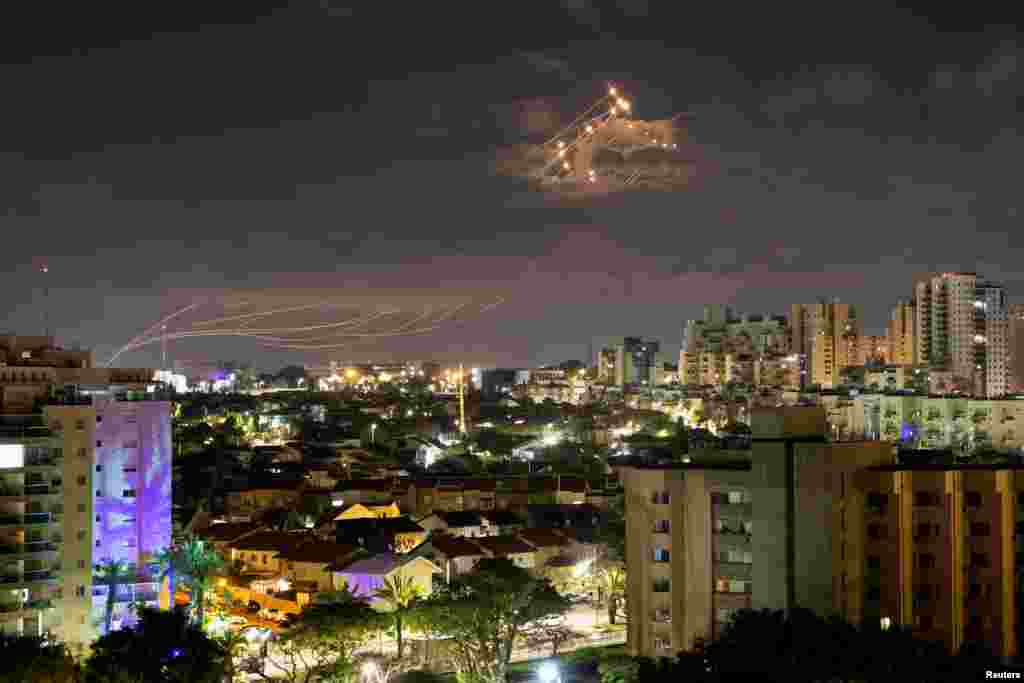 Streaks of light line the sky as Israel&#39;s Iron Dome anti-missile system intercepts rockets launched from the Gaza Strip toward Israel, as seen from Ashkelon.