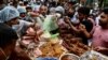 Pedagang kaki lima menyiapkan dan membagikan makanan untuk masyarakat sebelum berbuka puasa pada hari pertama bulan suci Ramadan, di sebuah pasar di Dhaka, Bangladesh, 3 April 2022. (Munir uz zaman / AFP)