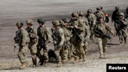 FILE - Members of the Polish 18th Mechanized Division and members of the U.S. 82nd Airborne Division participate in a joint military training to deepen the interoperability of their troops in Nowa Deba, Poland, Apr. 8, 2022.