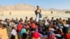 Matiullah Wesa, Afghan educational activist, reads a book to students at an open class in rural Afghanistan. (Photo courtesy of Matiullah Wesa) 