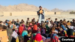 Matiullah Wesa, Afghan educational activist, reads a book to students at an open class in rural Afghanistan. (Photo courtesy of Matiullah Wesa)
