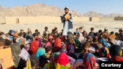 Matiullah Wesa, Afghan educational activist, reads a book to students at an open class in rural Afghanistan. (Photo courtesy of Matiullah Wesa)