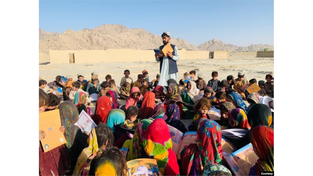 Matiullah Wesa, aktivis pendidikan Afghanistan, membacakan buku untuk siswa di kelas terbuka di pedesaan Afghanistan. (Foto: Istimewa/Matiullah Wesa)