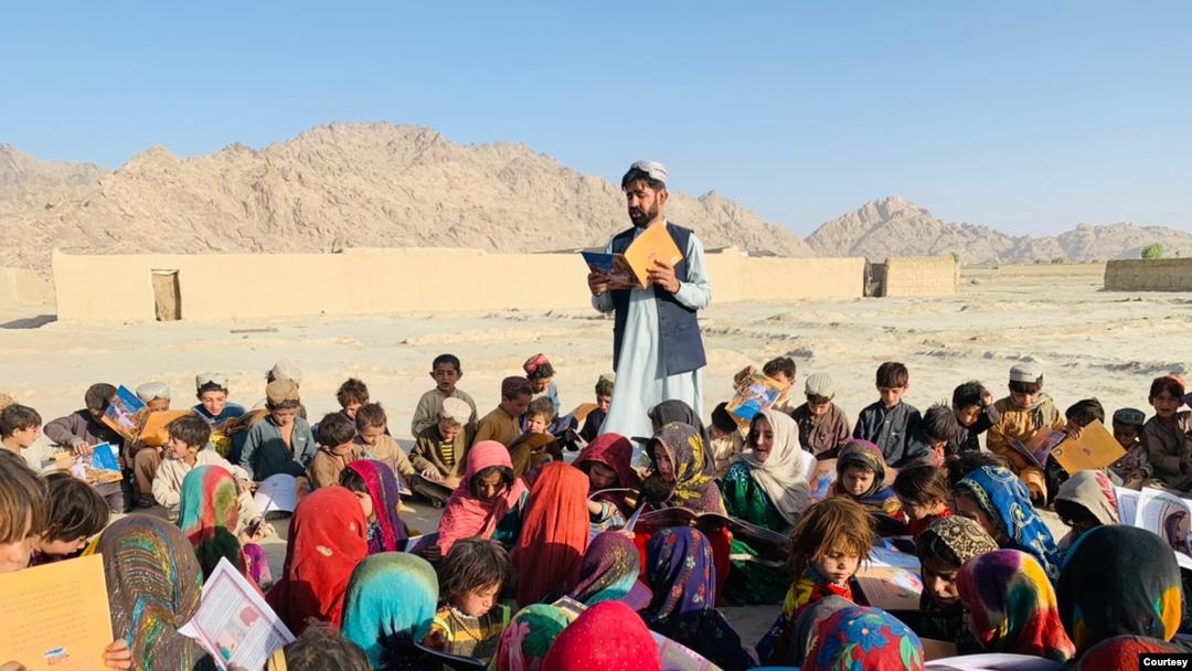 Afg'onistonlik ta'lim huquqlari faoli Matiulloh Vesa ochiq maydonda bolalarga dars o'tmoqda.
