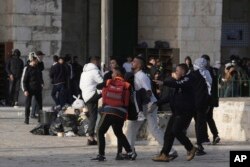 Seorang pengunjuk rasa Palestina yang terluka dalam bentrokan dengan polisi Israel dibawa ke tempat yang aman di kompleks Masjid al-Aqsa di Kota Tua Yerusalem, Jumat, 22 April 2022. (Foto: AP)