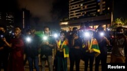 Demonstrators flash flashlights during a candlelight vigil after Sri Lankan police fired live ammunition to scatter protesters, near the Presidential Secretariat, amid the country's economic crisis, in Colombo, Sri Lanka, Apr. 19, 2022. 