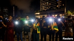 Demonstrators flash flashlights during a candlelight vigil after Sri Lankan police fired live ammunition to scatter protesters, near the Presidential Secretariat, amid the country's economic crisis, in Colombo, Sri Lanka, Apr. 19, 2022. 