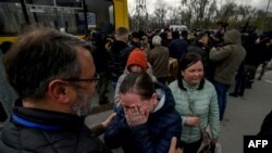 People fleeing fighting in the southern city of Mariupol meet with relatives and friends as they arrive in a small convoy that crossed through territory held by Russian forces, after the opening of a humanitarian corridor, at a registration center for int