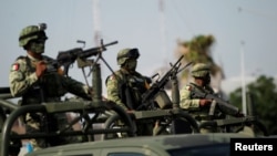 Soldados vigilan durante un operativo de seguridad para evitar secuestros y asaltos a viajeros en su paso por la carretera Monterrey-Nuevo Laredo en Sabinas Hidalgo, en las afueras de Monterrey, México, el 27 de junio de 2021.