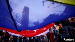 Supporters rallying for the nation’s new peace agreement with FARC hold a giant flag during a march in Bogota, Colombia, Nov.15, 2016.