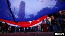 ARSIP - Para pendukung berkumpul dalam sebuah rapat besar terkait perjanjian perdamaian yang baru dengan FARC mengusung bendera raksasa dalam sebuah pawai di Bogota, Kolombia tanggal 15 November 2016 (foto: REUTERS/John Vizcaino)