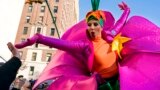 A participant in the Macy&#39;s Thanksgiving Day Parade touches hands with a spectator along Central Park West in New York.