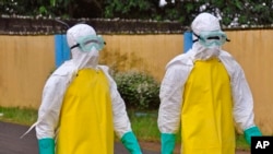 FILE - Health workers wearing protective gear go to remove the body of a person who is believed to have died after contracting the Ebola virus in the city of Monrovia, Liberia, Saturday, Aug. 16, 2014. 