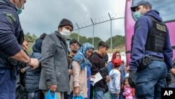 Los migrantes abordan en un ferry en el puerto de Mitilene para ser transferidos desde la isla de Lesbos a la tierra firme griega el 3 de mayo de 2020 en Moria.