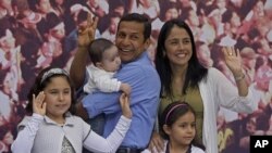 Peru's presidential candidate Ollanta Humala, of the political party Gana Peru, second left, and his family pose for photos during a traditional Peruvian breakfast on their patio in Lima, Peru, June 5, 2011