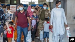 Porodice evakuisane iz Kabula, prolaze kroz terminal kako bi se ukrcale na autobus, nakon što su stigle u na aerodrom u Vašingtonu, 28. avgusta 2021.