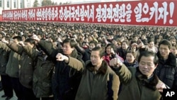 People pump their fists as about 100,000 North Koreans gather for an annual New Year rally to display loyalty to leader Kim Jong Il in Pyongyang, 03 Jan 2011
