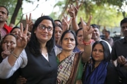 Asha Devi (tengah), ibu dari korban pemerkosaan beramai-ramai pada 2012, mengacungkan tanda kemenangan setelah pemerkosa anaknya dihukum gantung, di New Delhi, India, 20 Maret 2020. (Foto: AP)