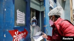 Una mujer solicita información sobre su familiar que ingresó en una sala de pacientes con la enfermedad por coronavirus (COVID-19), en el Hospital de Clínicas de La Paz, Bolivia, el 5 de enero de 2021.