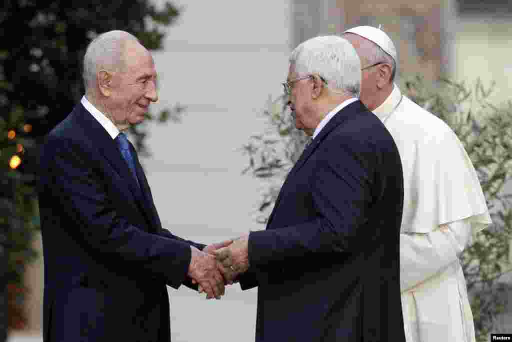 Israeli President Shimon Peres shakes hands with Palestinian President Mahmoud Abbas as Pope Francis watches after a prayer meeting at the Vatican, June 8, 2014.