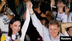 Edmundo González Urrutia, candidato presidencial de la Plataforma Unitaria en Venezuela, alza la mano junto a la dirigente María Corina Machado, en el acto de cierre de campaña en Caracas, el 25 de julio de 2024.