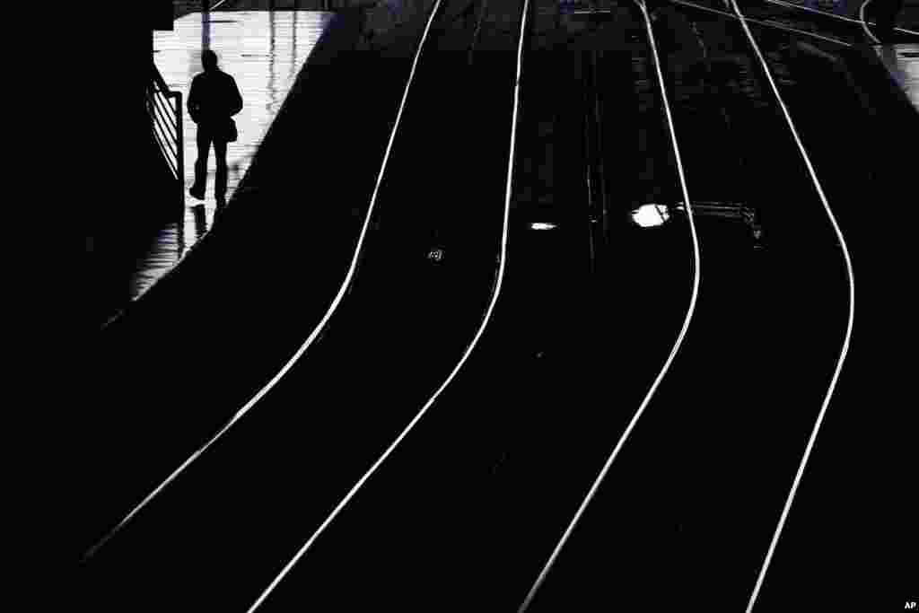 A passenger waits for a train as he walks along a platform at the Atocha train station during a 24-hour partial train strike in Madrid, Spain.