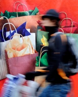 In this file photos, a man passes a banner with Christmas gifts in downtown Hamburg, Germany, on Saturday, Dec 20, 2008. (AP Photo/Fabian Bimmer)