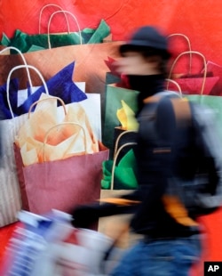 In this file photos, a man passes a banner with Christmas gifts in downtown Hamburg, Germany, on Saturday, Dec 20, 2008. (AP Photo/Fabian Bimmer)