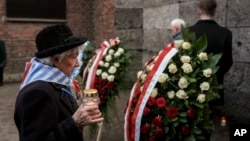 A survivor brings a candle to the Death Wall at the Auschwitz-Birkenau former Nazi German concentration and extermination camp, during a ceremony marking the 80th anniversary of the camp's liberation, in Oswiecim, Poland, Jan. 27. 2025.