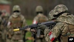 Tân binh Ukraine, dưới sự hướng dẫn của binh sĩ Anh, huấn luyện tại một trại quân đội ở Tây Nam nước Anh ngày 20/2. Pháp có thể cửa người tới huấn luyện cho quân đội Ukraine tại chính nước này.