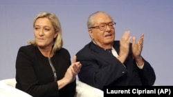 Jean-Marie Le Pen, à droite, applaudit aux côtés de sa fille Marine Le Pen, lors d'une réunion du Front National (AP Photo/Laurent Cipriani, File)