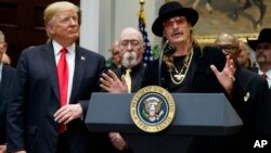 Presiden AS Donald Trump dan musisi Kid Rock (kanan) dalam upacara penandatanganan RUU Royalti Gedung Putih hari Kamis (11/10). 