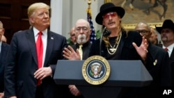 President Donald Trump looks on as musician Kid Rock speaks during a signing ceremony for the "Orrin G. Hatch Music Modernization Act," in the Roosevelt Room of the White House, Oct. 11, 2018, in Washington.