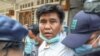 Voice of Myanmar editor-in-chief Nay Myo Lin is escorted from his home by police to court in Mandalay on March 31, 2020.