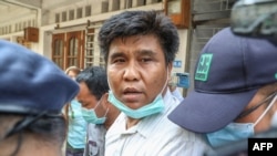 Voice of Myanmar editor-in-chief Nay Myo Lin is escorted from his home by police to court in Mandalay on March 31, 2020.