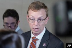 FILE - Rep. Dusty Johnson, R-S.D., talks to reporters during the Republican caucus meeting on Capitol Hill October 24, 2023, in Washington