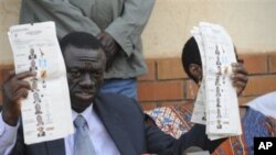 Forum for Democratic Change opposition leader Dr. Kizza Besigye displays pre-marked ballot papers, during a news conference at party headquarters in Kampala Uganda (file photo)