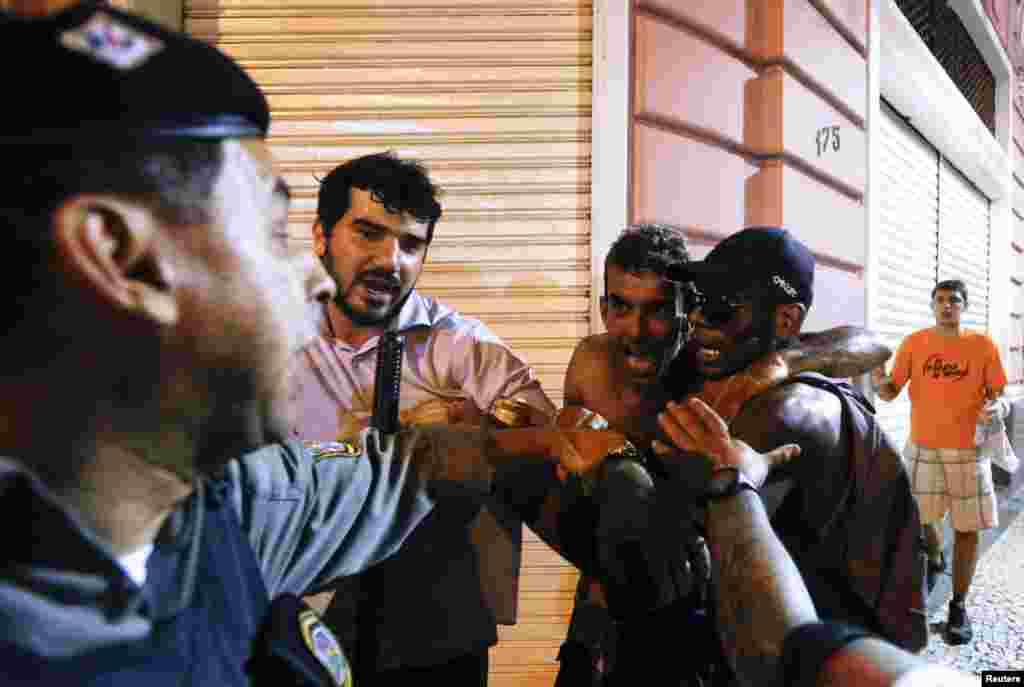 A policeman tries to arrest demonstrators during a protest against the Confederations Cup and the government of Brazil's President Dilma Rousseff in Recife City June 20, 2013. The demonstrators were fighting after a group tried to stop several fellow prot