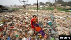 FILE - A Bangladeshi girl plays on a swing, in Dhaka, Bangladesh.