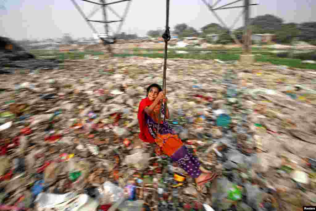 A girl plays on a swing in Dhaka, Bangladesh.