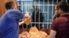 Warga Palestina antre untuk membeli roti dari sebuah bakeri yang telah dibuka kembali di kota Gaza, Minggu (14/4). 