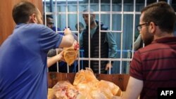 Warga Palestina antre untuk membeli roti dari sebuah bakeri yang telah dibuka kembali di kota Gaza, Minggu (14/4). 