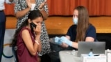 FILE - A high school student reacts after getting a COVID-19 vaccine shot in New York City, July 27, 2021. 