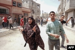 FILE—Palestinians react to an Israeli strike on al-Bureij camp in the central Gaza Strip on April 22, 2024, amid ongoing battles between Israel and the militant group Hamas.