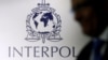 FILE PHOTO: A man passes an Interpol logo during the handing over ceremony of the new premises for Interpol's Global Complex for Innovation in Singapore